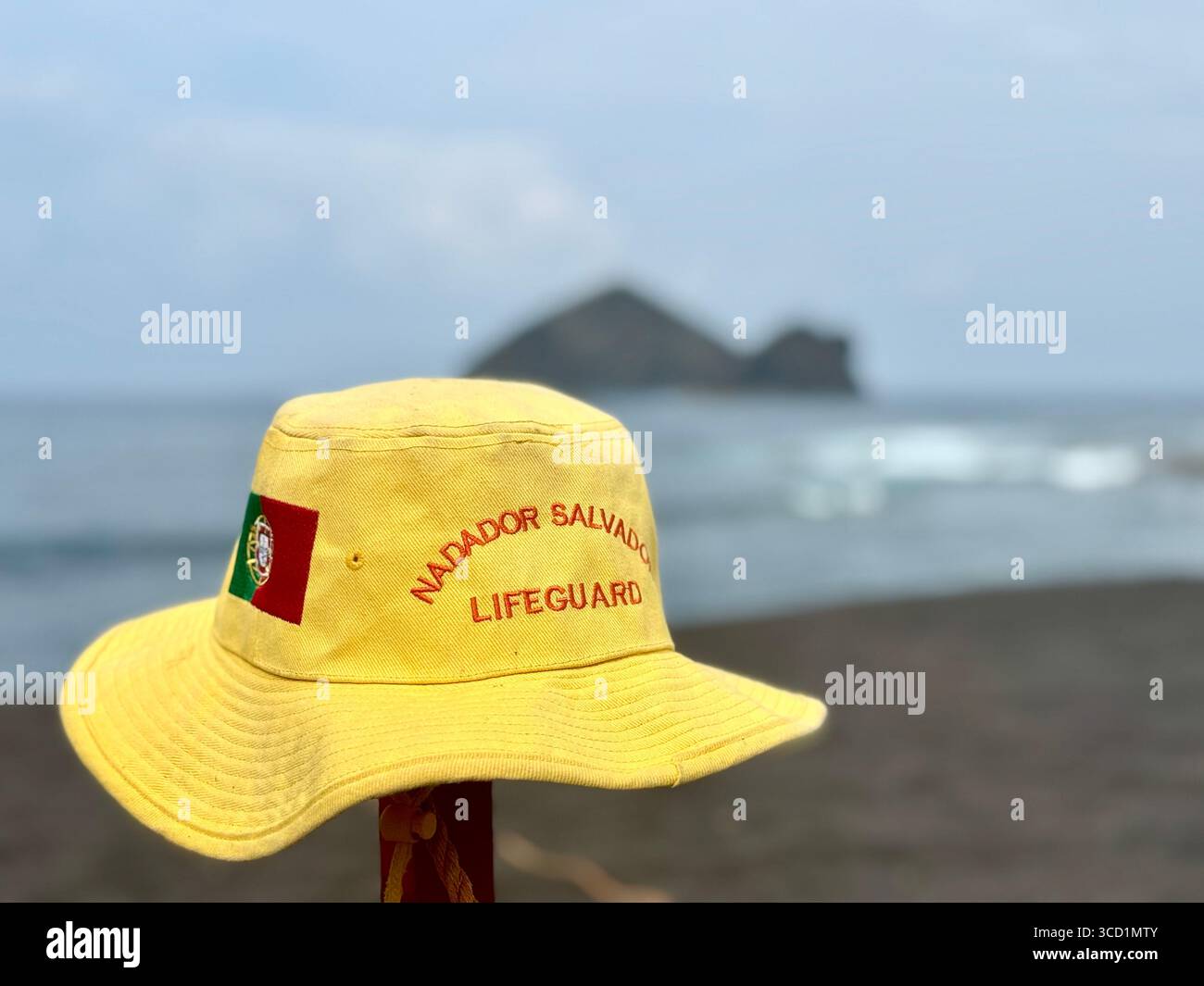 Yellow lifeguard hat with Portuguese flag on Mosteiros Beach, Azores. - Smartphone Captured Stock Image