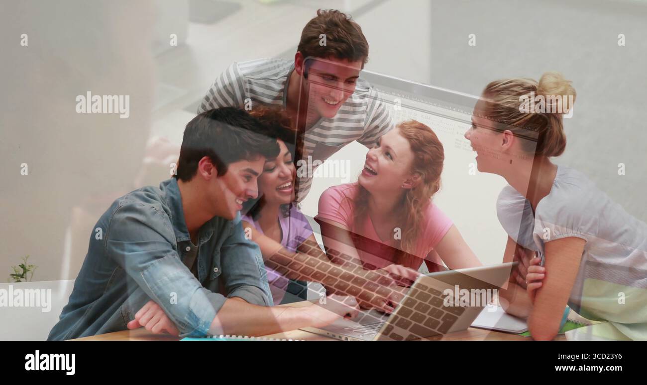 Collaborating study group typing, discussing in study lounge, with laptop, notebooks Stock Photo