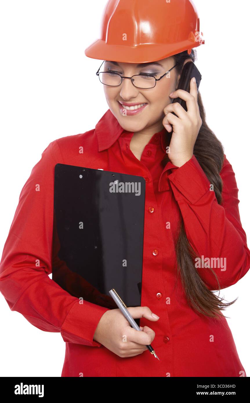 Female architect holding clipboard, using cell phone Stock Photo