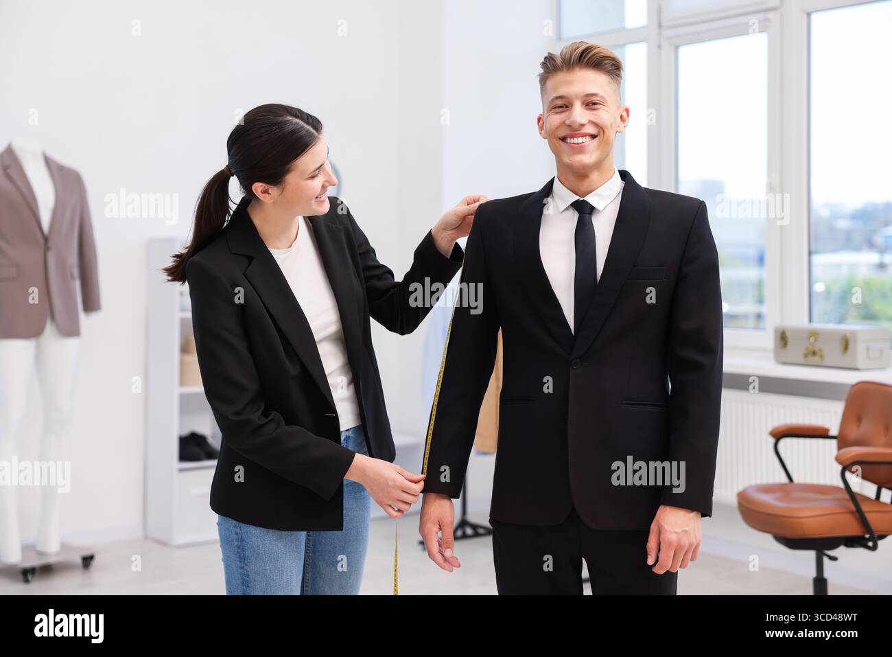 Tailor measuring jacket on man in atelier Stock Photo