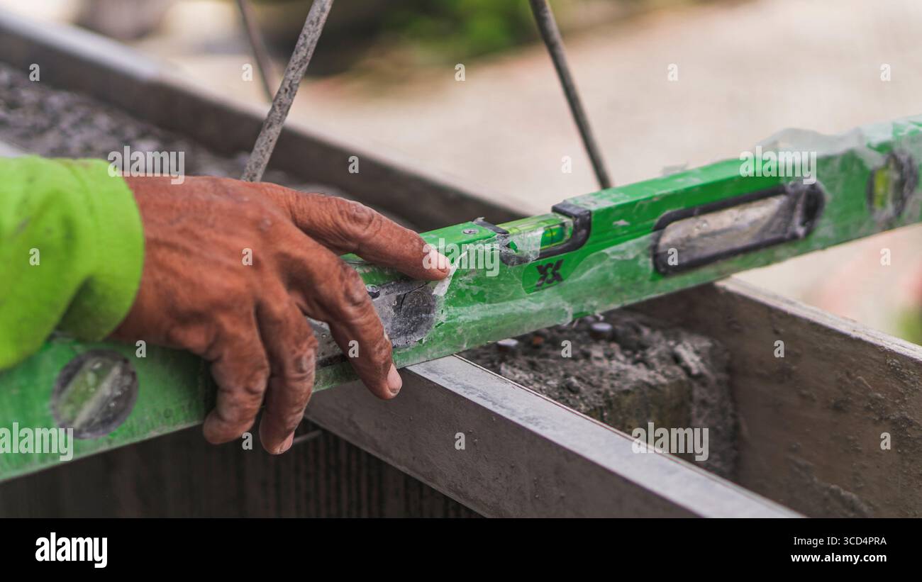 A spirit level rests on concrete to ensure surface evenness, an essential step in maintaining precision and quality in construction work Stock Photo