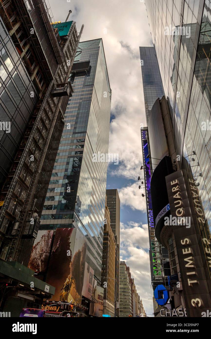 Looking up from the street at Times Square, Manhattan, New York City, USA, capturing towering buildings, urban energy, and city lights Stock Photo