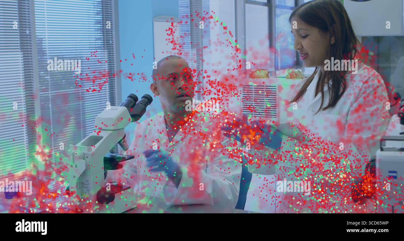 Two scientists examining samples under microscope in lab, wearing ...