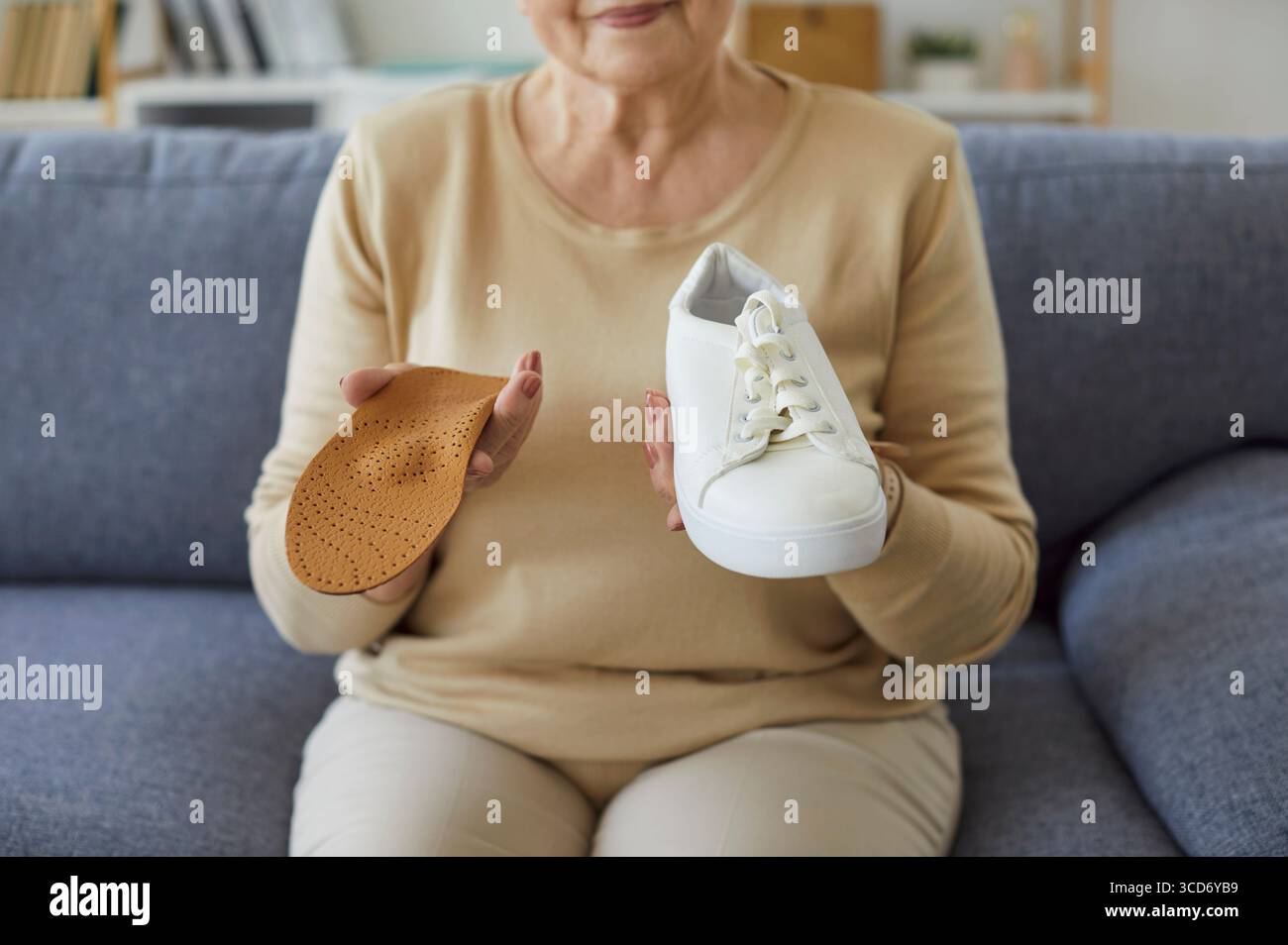 Close-Up Of Senior Woman Holding Shoe And Insole At Home Stock Photo