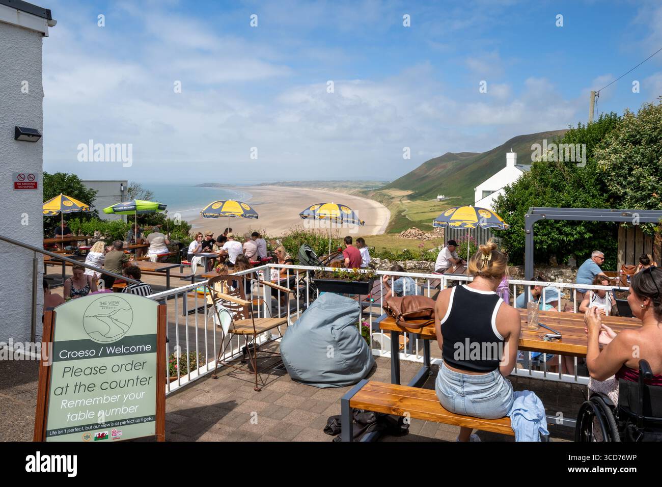 The View, busy cafe and bar with people sitting at outside tables overlooking Rhossili Bay Beach, Rhossili, Gower Peninsula, South Wales, UK Stock Photo