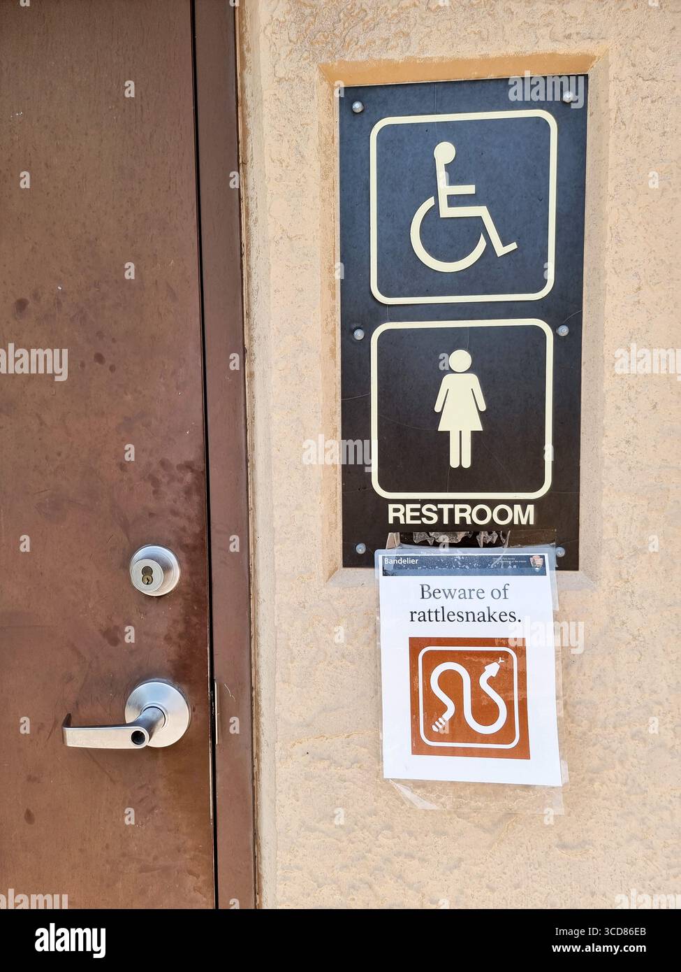 Beware of rattlesnakes; added sign warning for snakes at toilet restroom toilet for women & handicapped - Smartphone Captured Stock Image