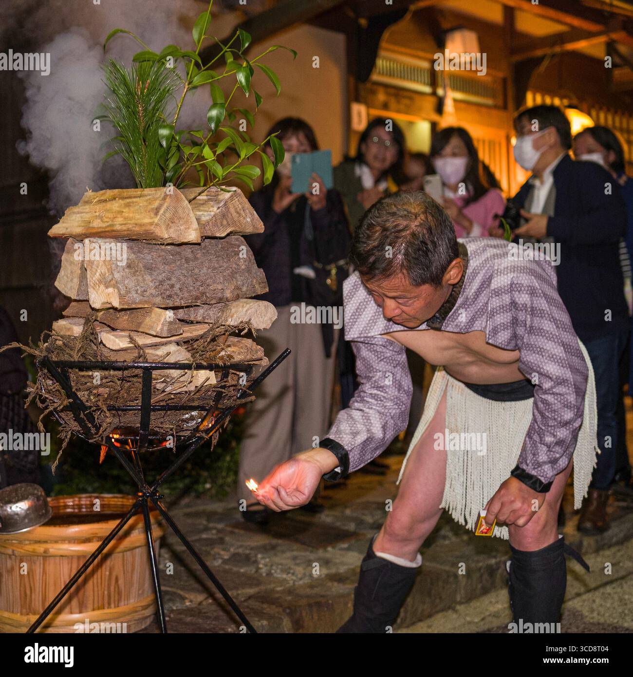 Japanese man wearing traditional cultural attire lighting a fire in ...