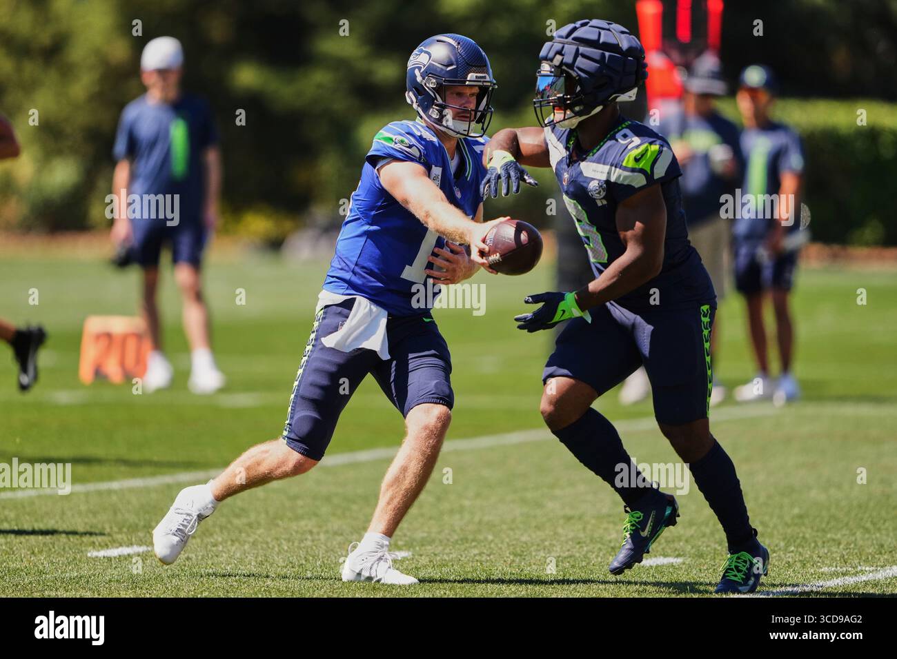 Seattle Seahawks quarterback Sam Darnold hands off the ball to running ...