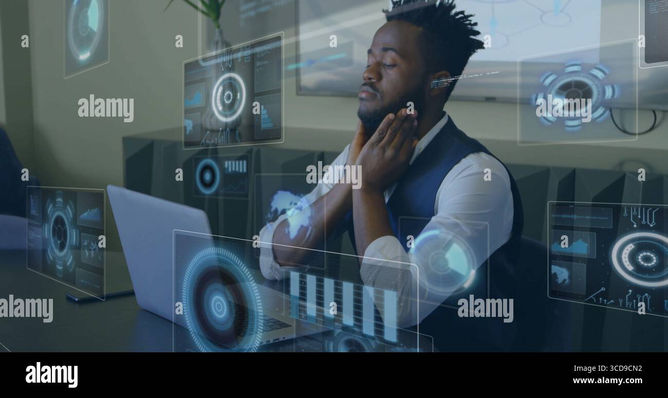 Working professional touching jawline while analyzing holographic data at tech office, with laptop Stock Photo