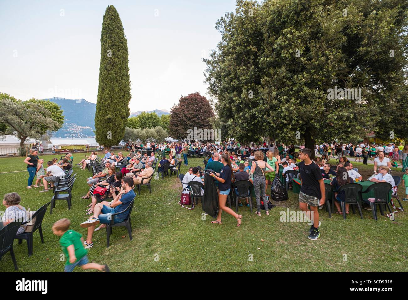 People sitting on plastic chairs waiting for start of performance, Menaggio, Province of Como, Lombardy, Italy Stock Photo