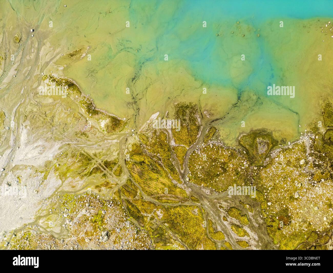 Aerial view of turquoise waters meet the earthy tones of the landscape ...
