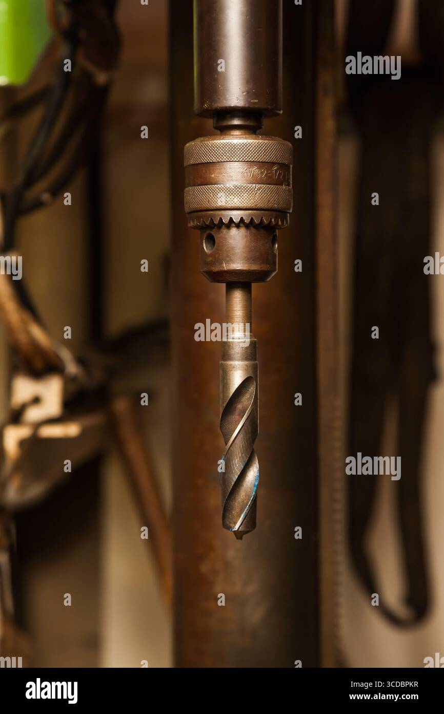 A drill inserted into a chuck on a drilling machine. Stock Photo