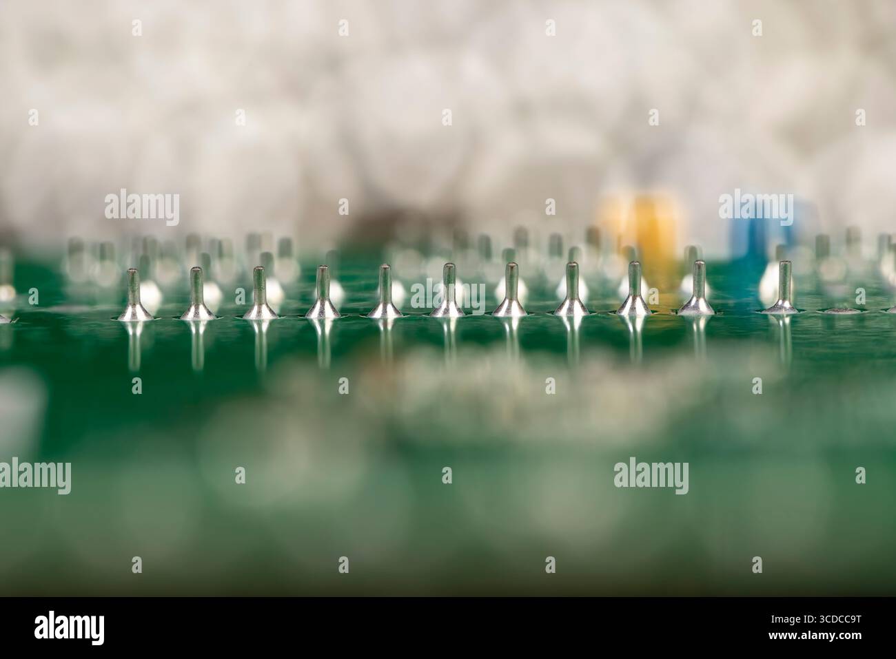 green circuit board with contacts, a simple green printed circuit board with an electronic circuit with soldered elements Stock Photo