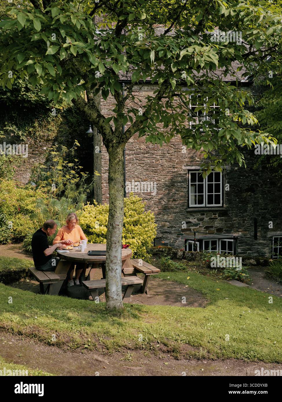Couple enjoying a cream tea in a garden Stock Photo