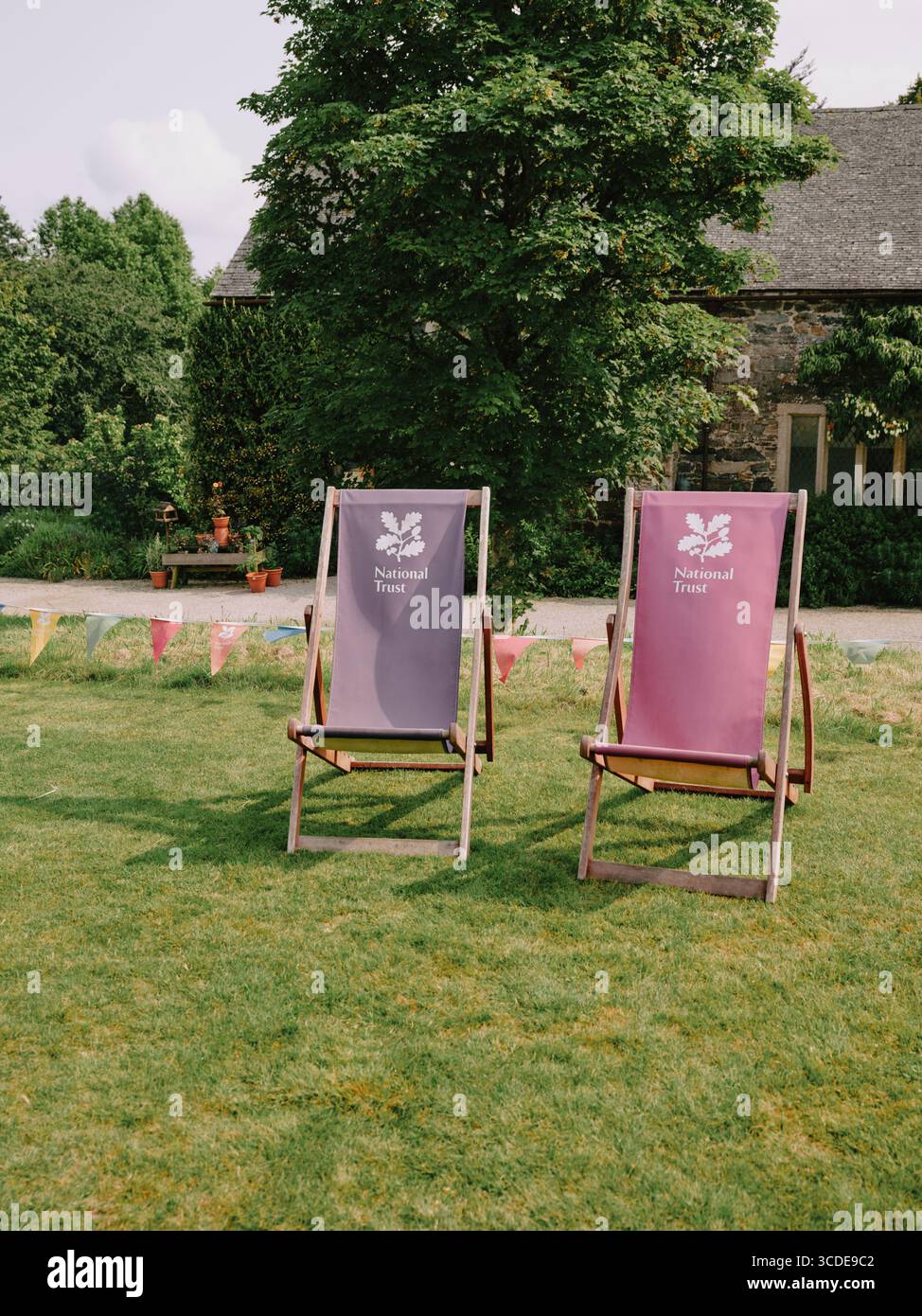 National Trust summer deckchairs ready for use on a summer garden lawn Stock Photo