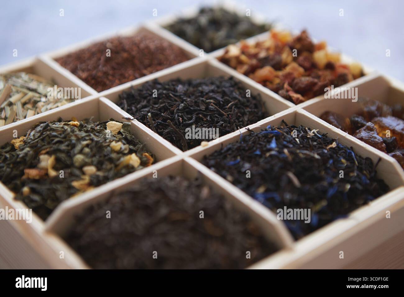 Various kind of dry tea - green, black, red, fruit and blue in wooden box on the table. Top view. Tea time concept Stock Photo