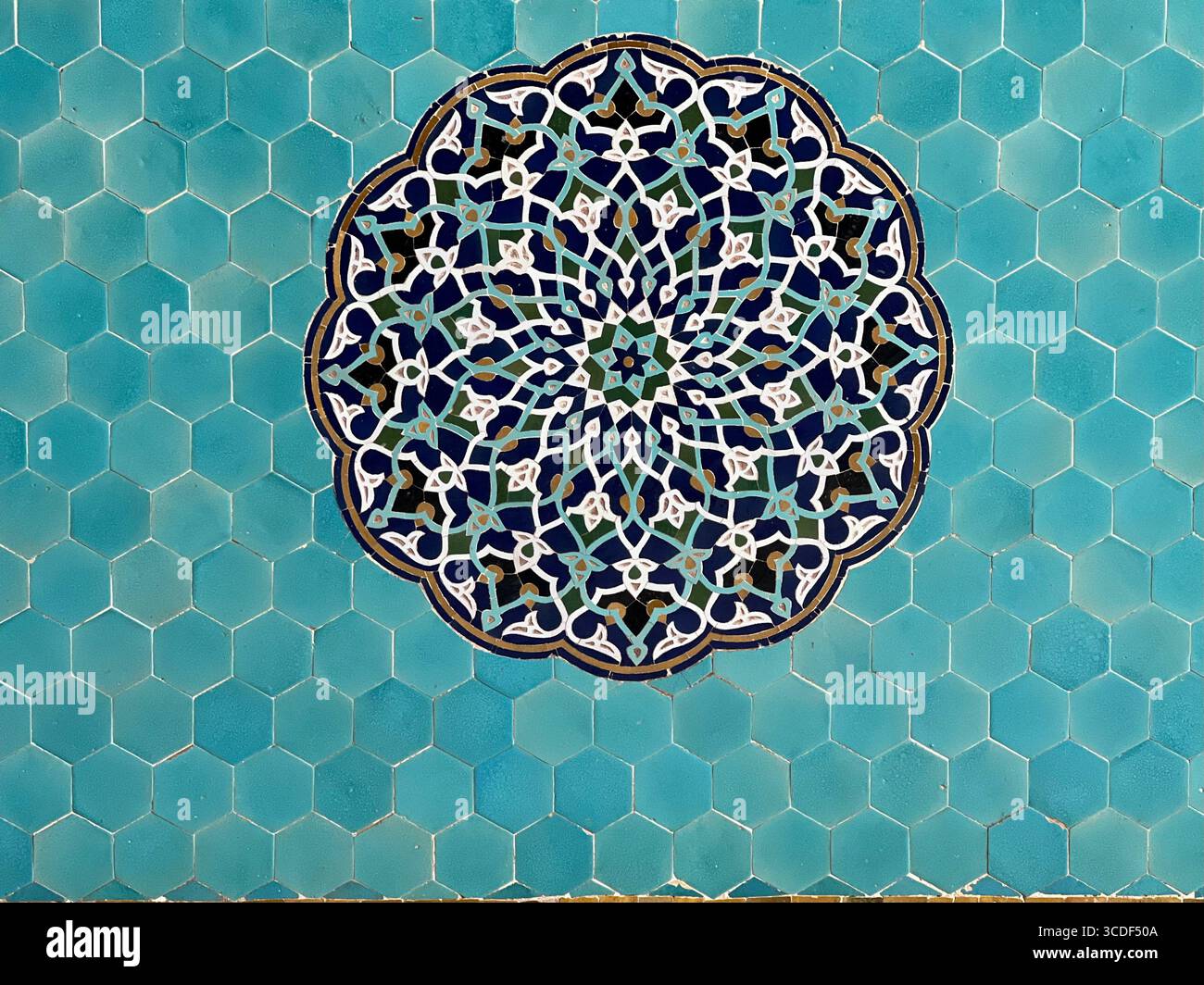 Traditional Persian tilework with an intricate geometric and floral pattern in blue and turquoise tones, Iran. Stock Photo