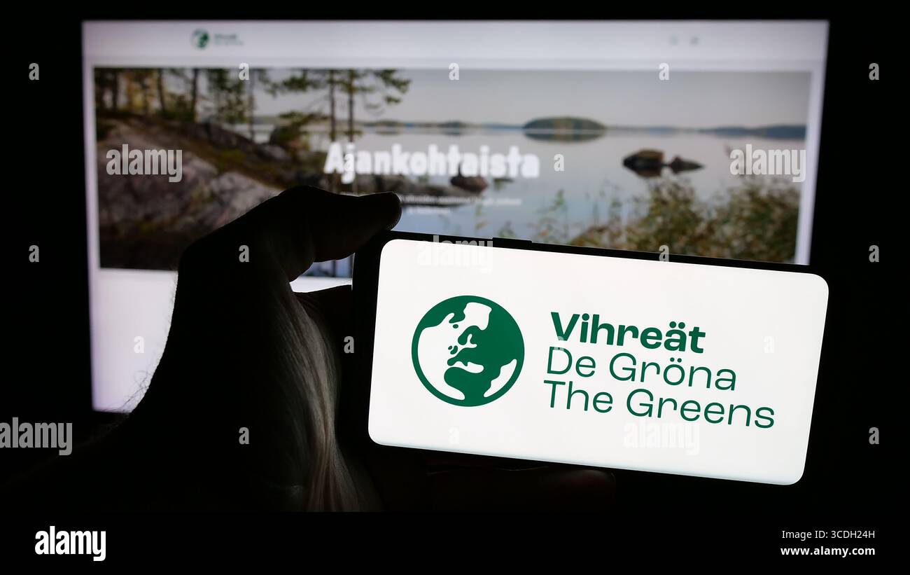 Stuttgart, Germany - 07‑25‑2025: Person holding mobile phone with logo of Finnish political party Vihrea Liitto (Vihreat) on screen Stock Photo
