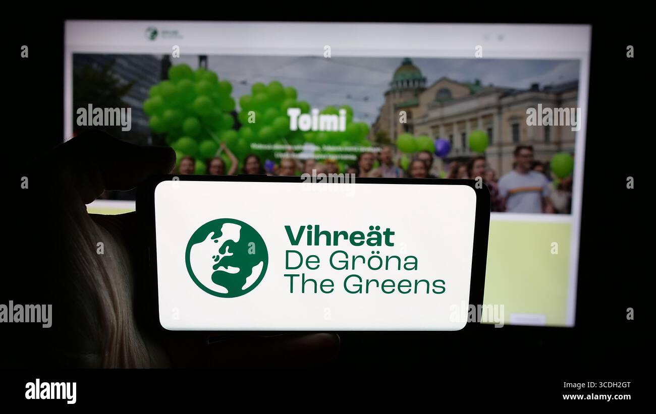 Stuttgart, Germany - 07‑25‑2025: Person holding cellphone with logo of Finnish political party Vihrea Liitto (Vihreat) on screen in front of webpage. Stock Photo