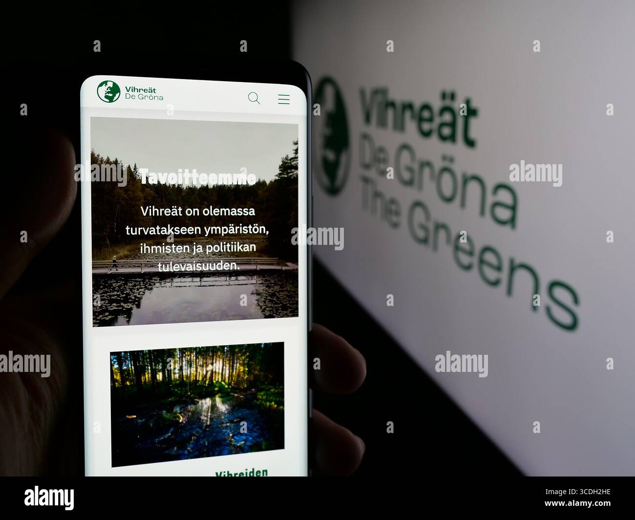 Stuttgart, Germany - 07‑25‑2025: Person holding cellphone with webpage of Finnish political party Vihrea Liitto (Vihreat) on screen in front of logo. Stock Photo