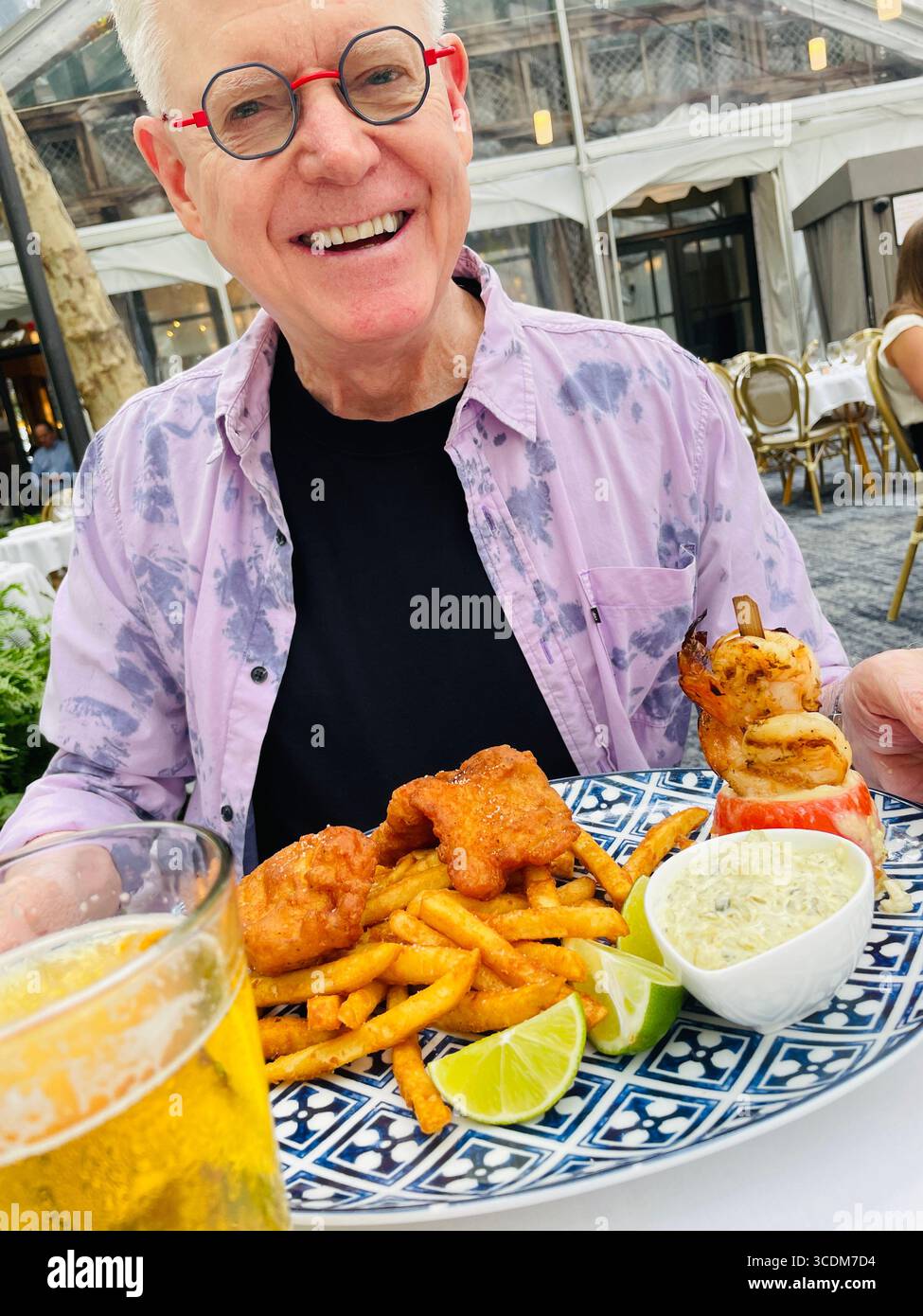 Senior man Outdoor Dining at the Bryant Park Grill Restaurant is festive in summertime, Bryant Park, NYC, USA, 2025 - Smartphone Captured Stock Image
