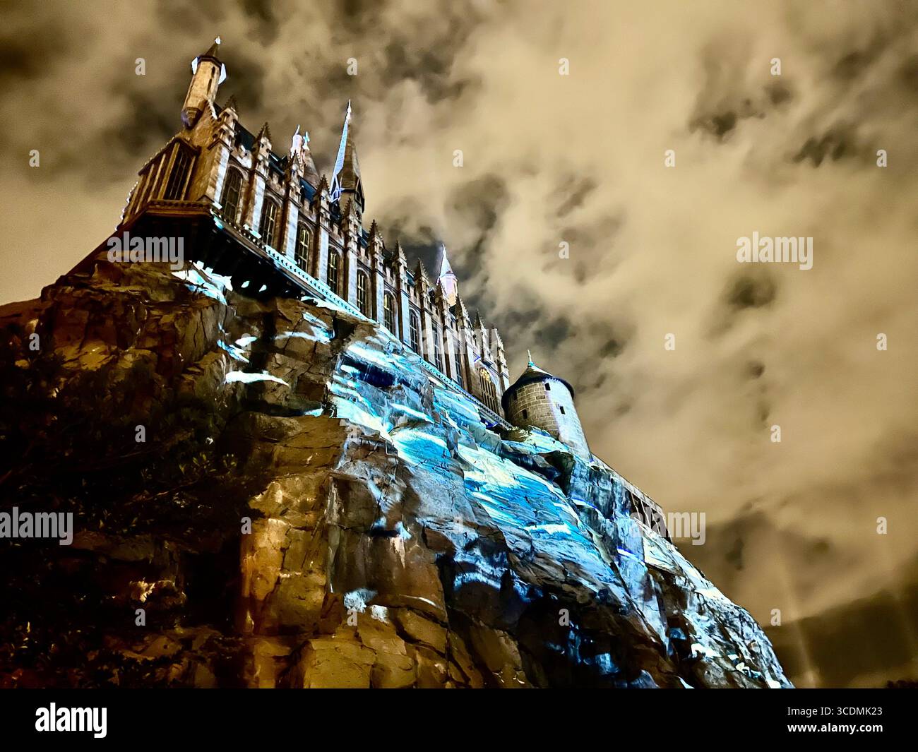 Heavily clouded dark sky looming overhead gives an eerie perspective to the Hogwarts Castle in The Wizarding World of Harry Potter, Universal,Orlando. - Smartphone Captured Stock Image