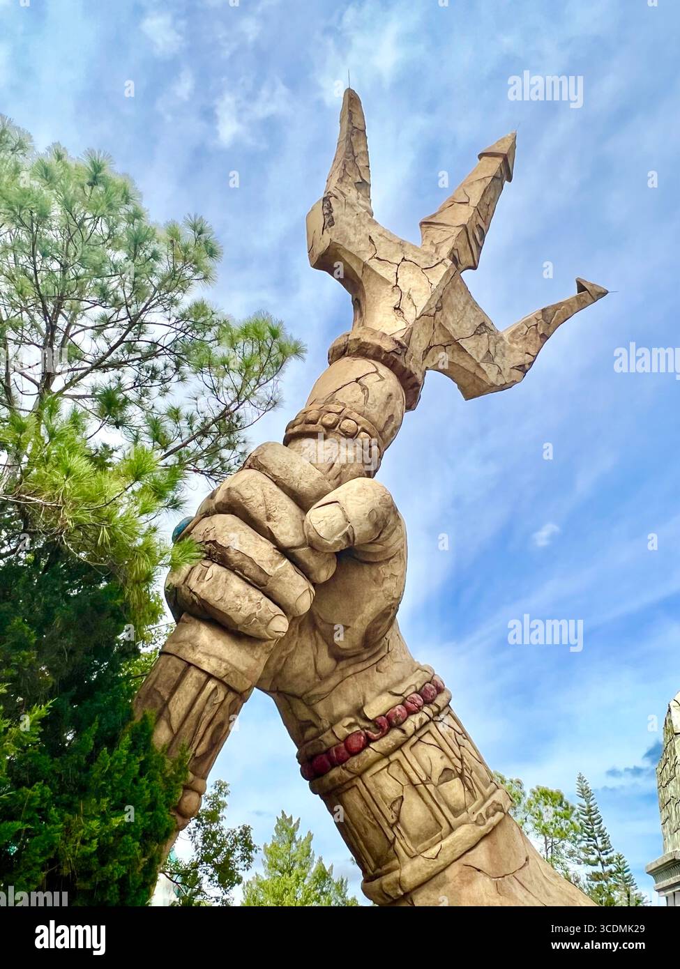 the arm of Poseidon holding his trident up outside of the Poseidon's Fury water ride at Universal Orlando. This attraction was closed in 2023. - Smartphone Captured Stock Image