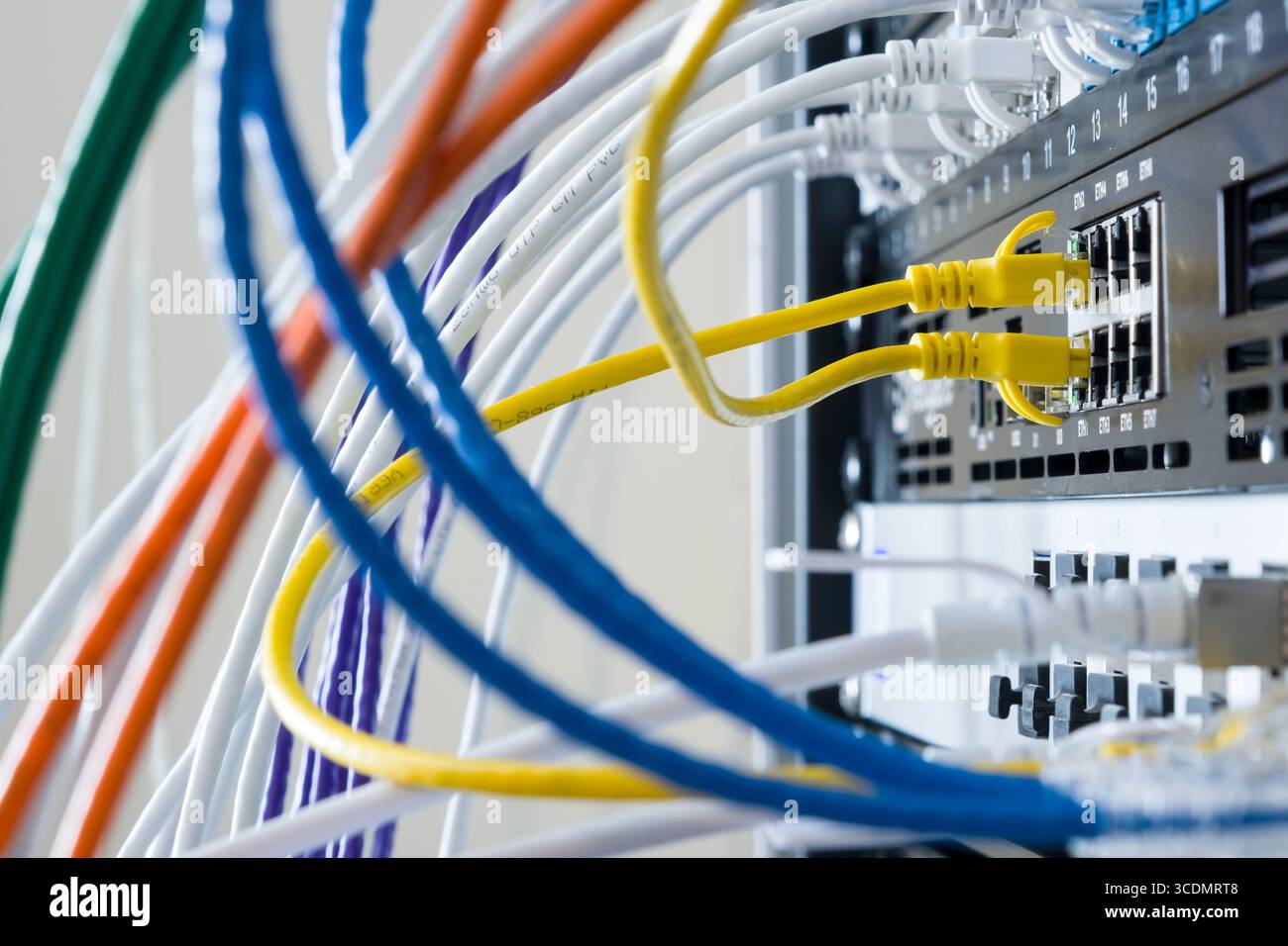 Yellow Ethernet patch cables connecting Netgate 7100 firewall appliance running pfsense to local area network Stock Photo