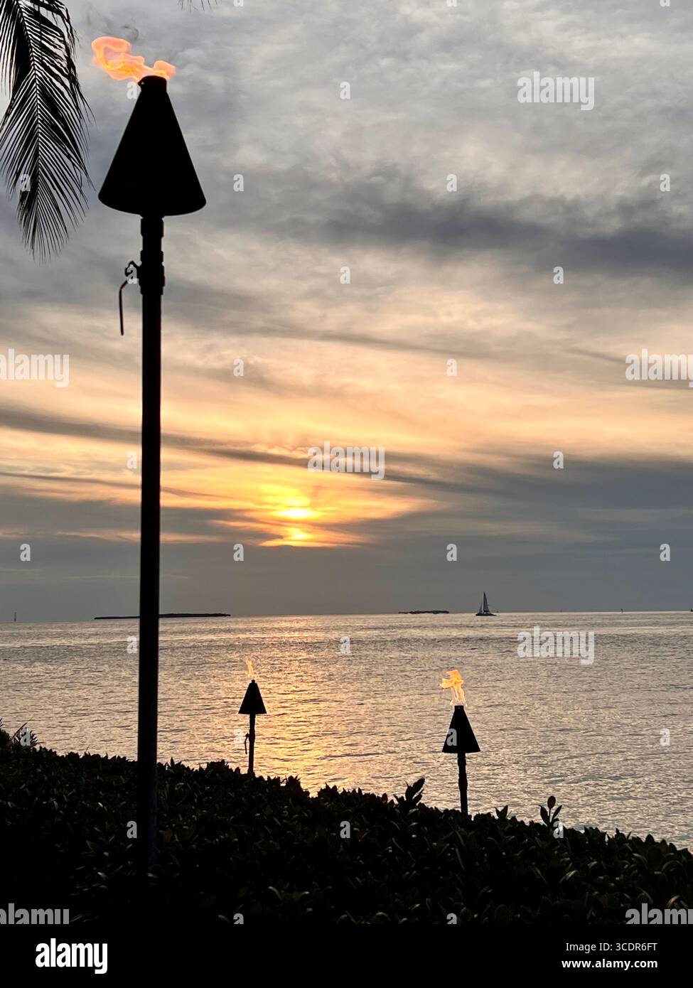 Burning torch lamps and sunset glow on Sunset Key - Smartphone Captured Stock Image
