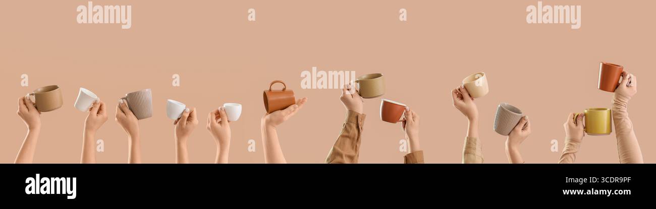 Many hands holding ceramic cups on beige background Stock Photo