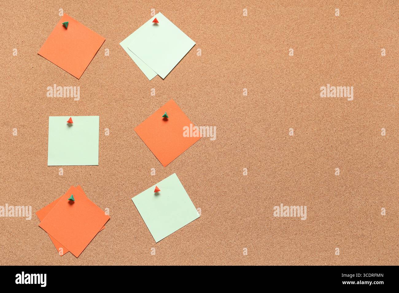 Blank sticky notes with pins on cork board as background Stock Photo