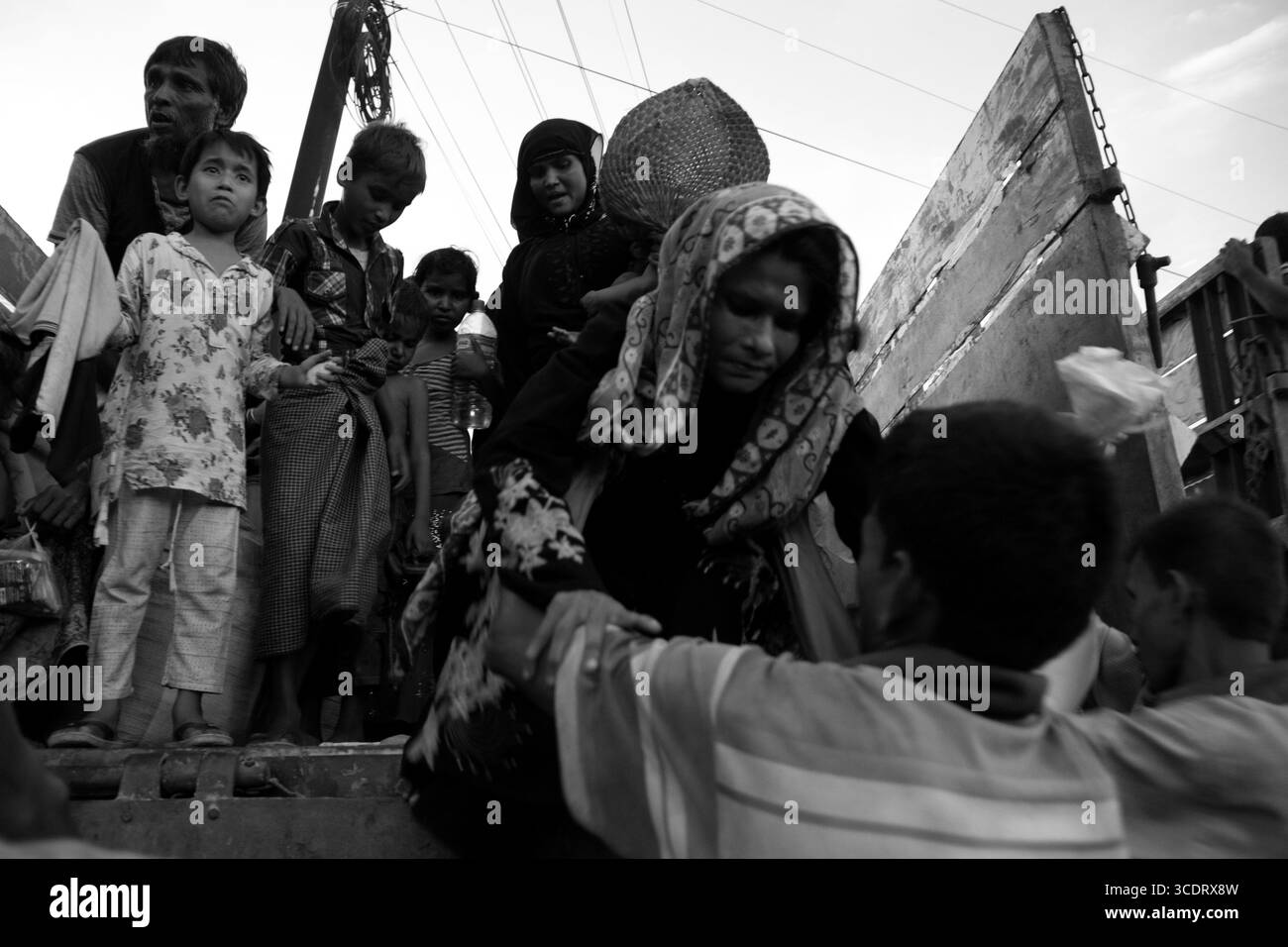 Rohingya refugees arrive in groups at Kutupalong camp, carrying children and newborns after crossing the Bangladesh border. Stock Photo