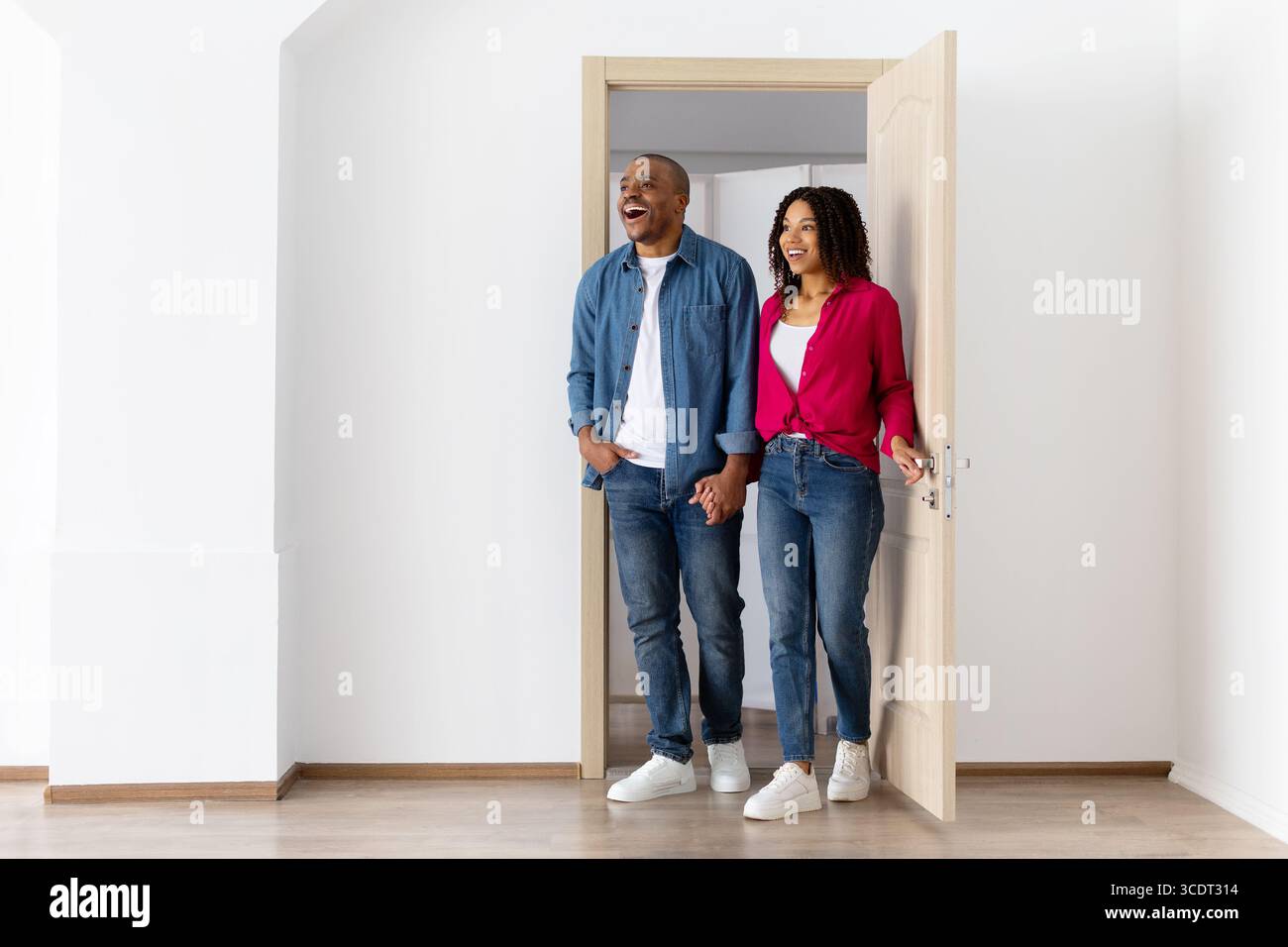 Excited young African American couple entering bright new home after ...