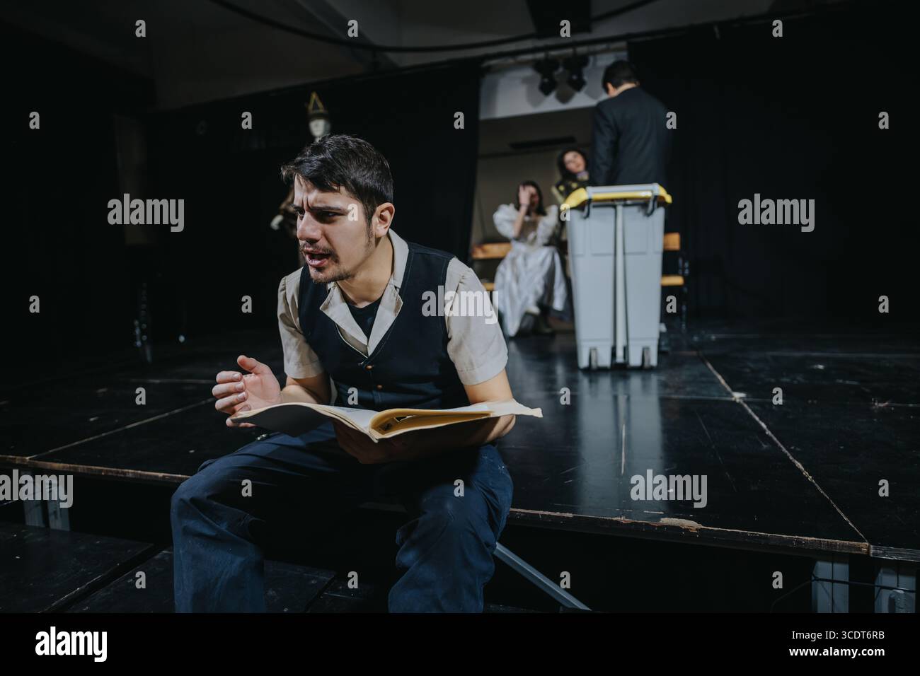 Young actors performing a dramatic scene on a theater stage with ...