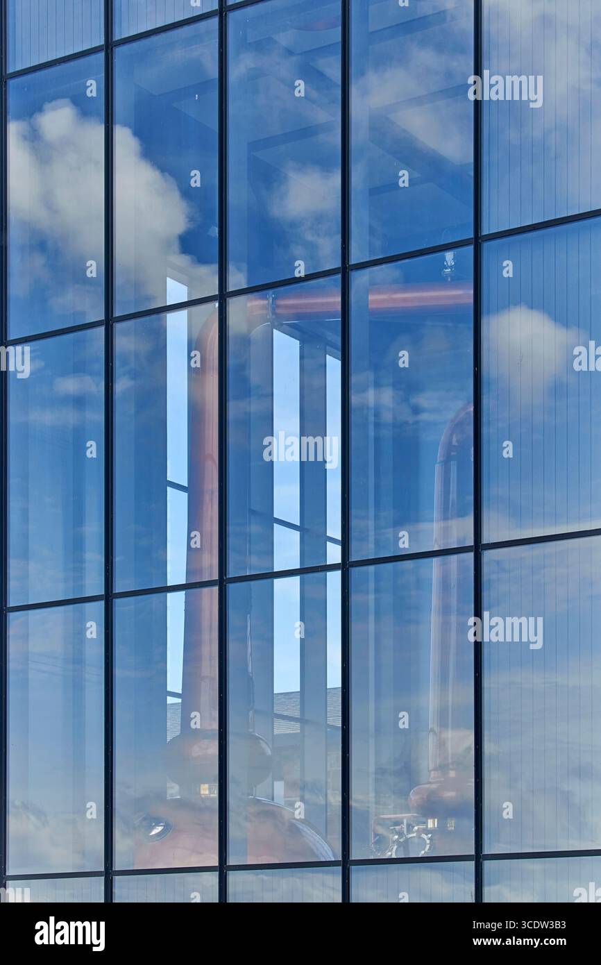 Glenmorangie distillery Tain Ross-shire Scotland  blue sky and clouds copper whisky stills seen through glass windows of the tall building Stock Photo