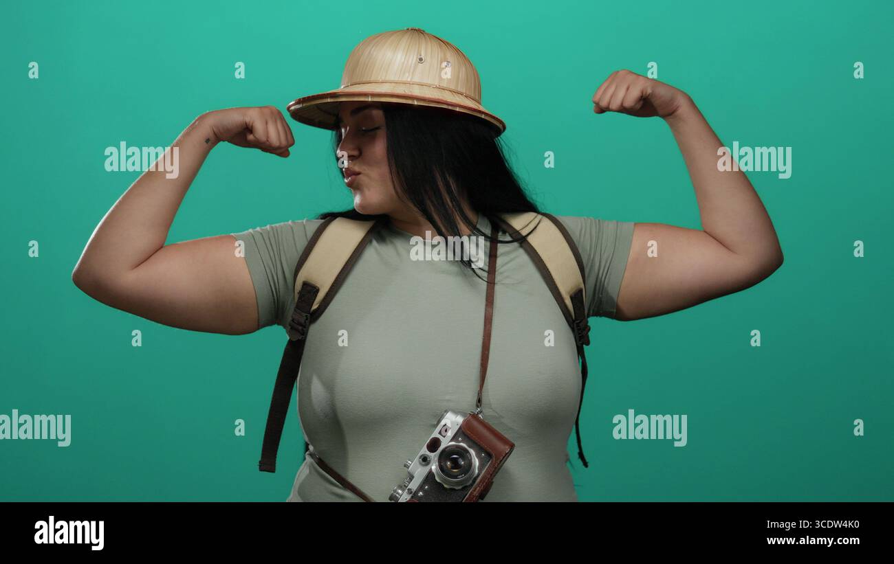 Curvy woman flexing muscles posing confidently with camera and backpack ...