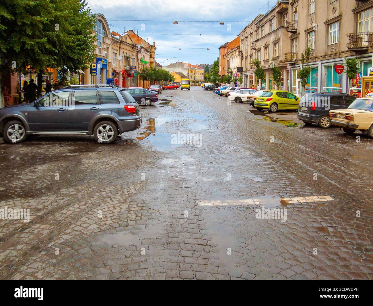 uzhhorod, ukraine - 01 jul, 2007: city after the rain with wet street. beautiful architecture of the historic center. water on the sidewalk. urban lan Stock Photo