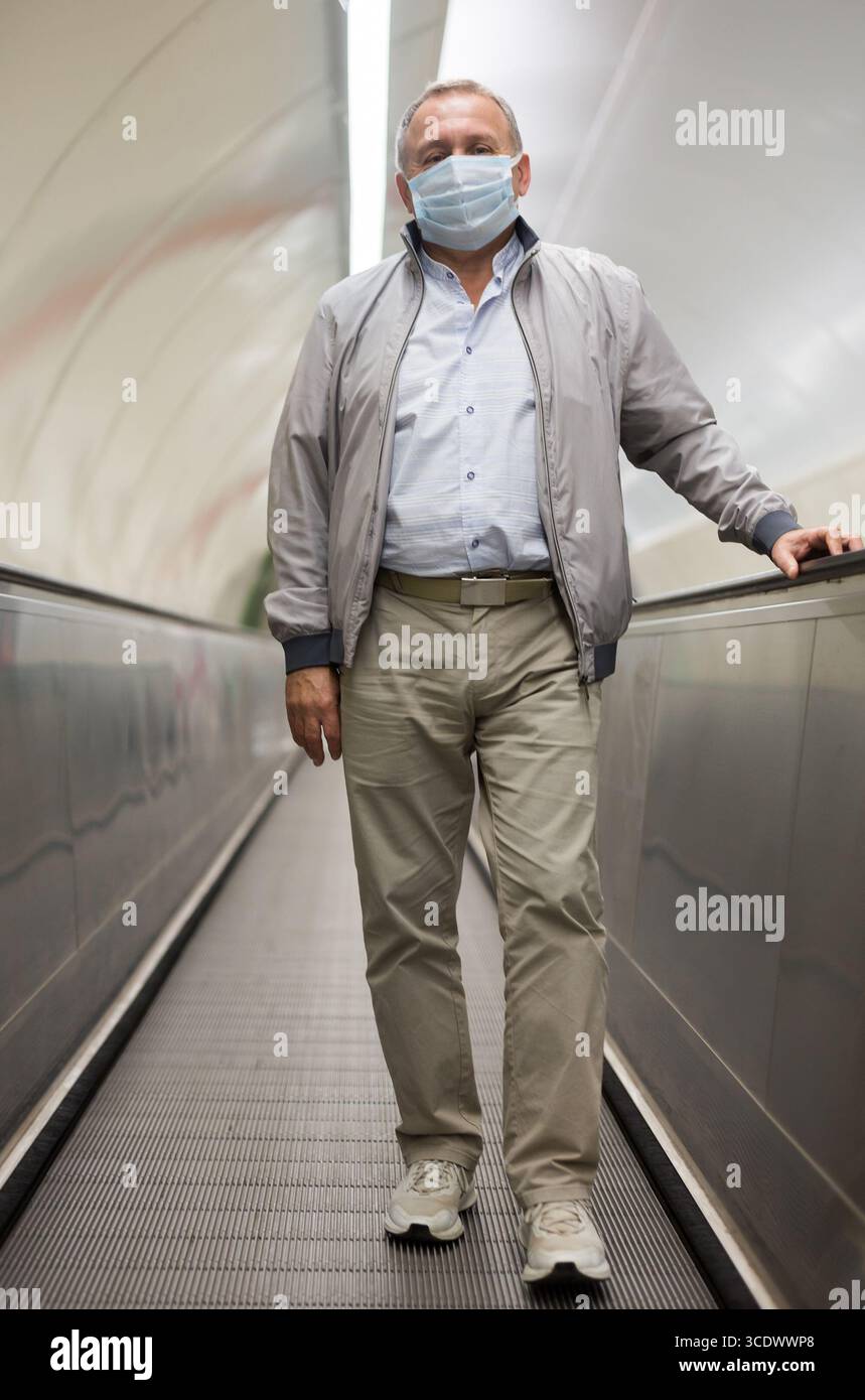Middle aged man on moving walkway Stock Photo