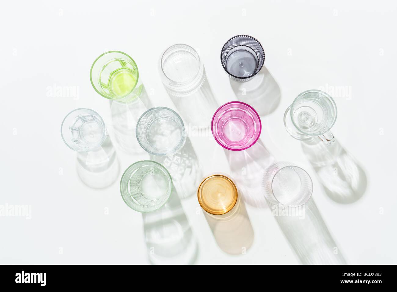 Drinking glasses on white background top view. Colored glass. Stock Photo
