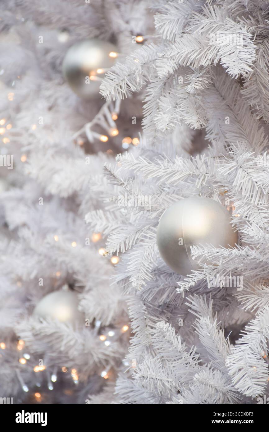 White decorations on artificial white Christmas tree with copy space Stock Photo