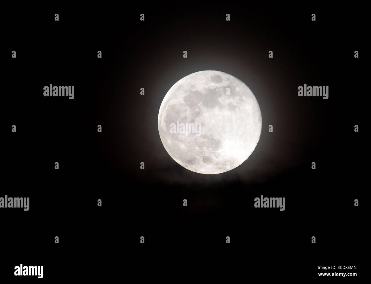 Close-up of a bright full moon against a dark night sky, showing ...