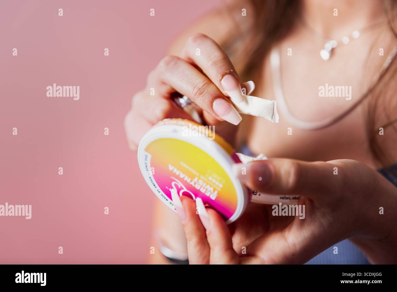 Girl using white nicotine pouches, white snus.Photo: Josefine Stenersen ...