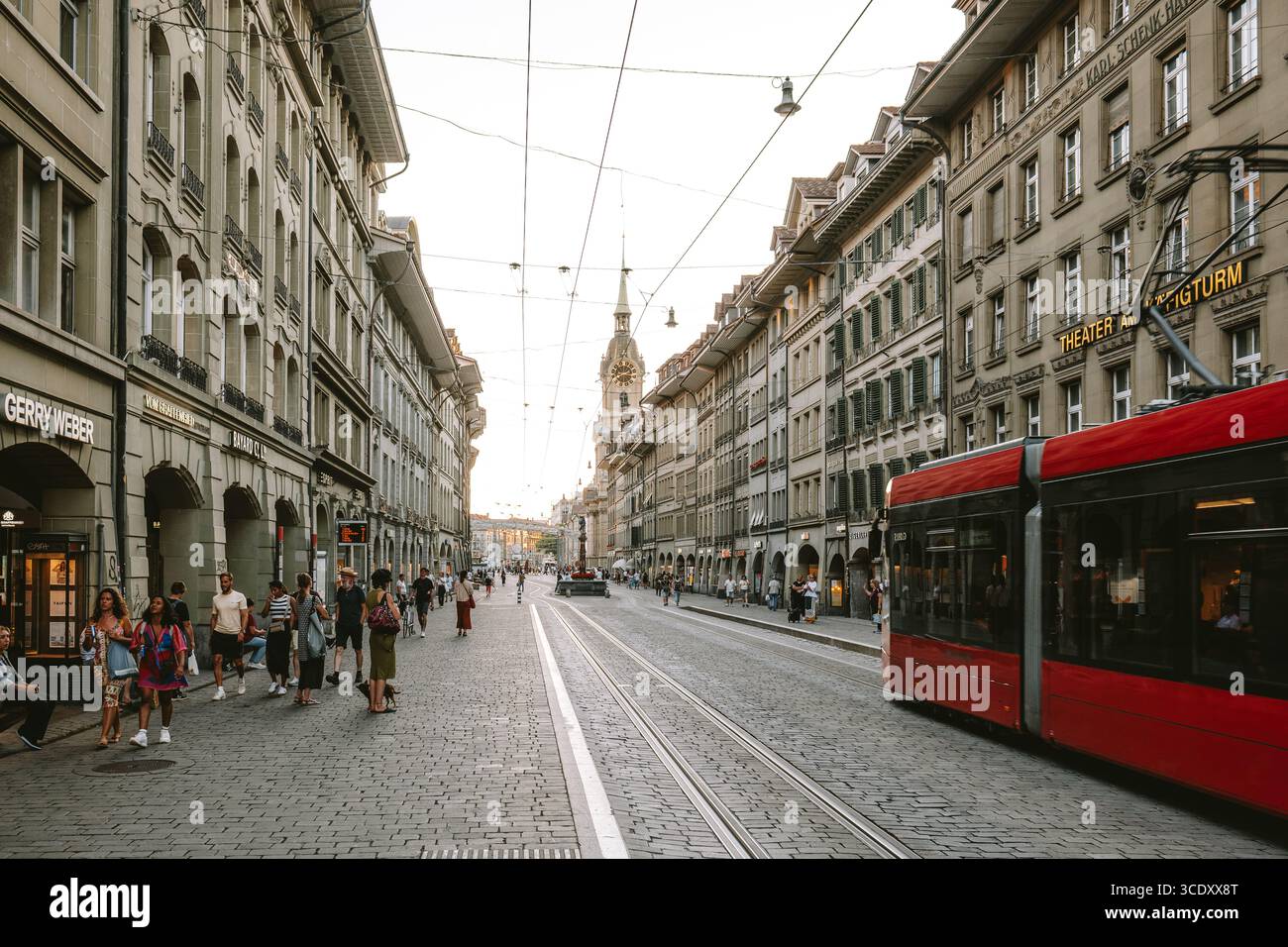 07-08-2025 Bern, Switzerland. Red tram and tourists on Spitalgasse near Barenplatz station. Sunny summer evening, wide angle view Stock Photo