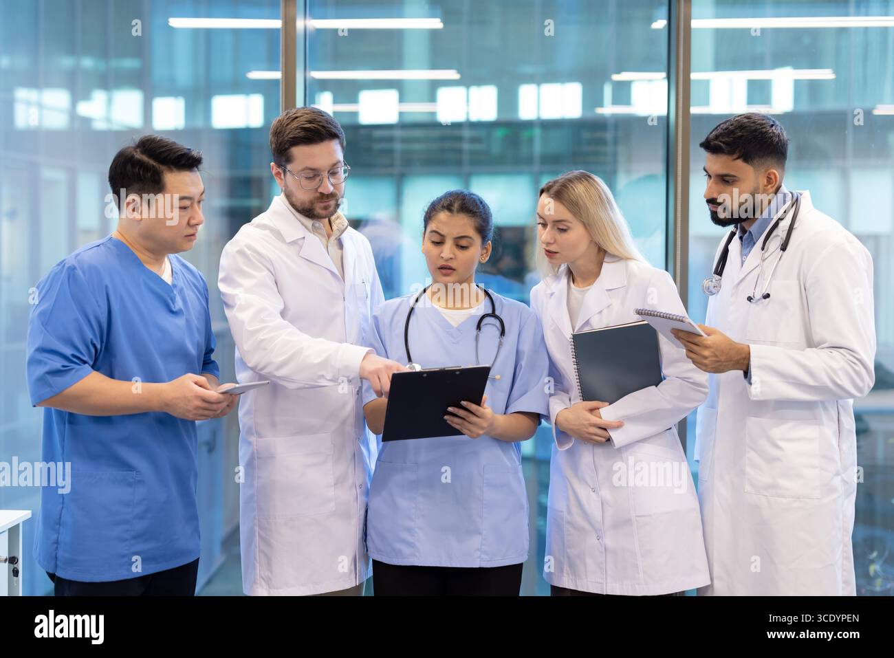 Healthcare team in a professional setting reviewing documents and collaborating on patient diagnostics. Stock Photo