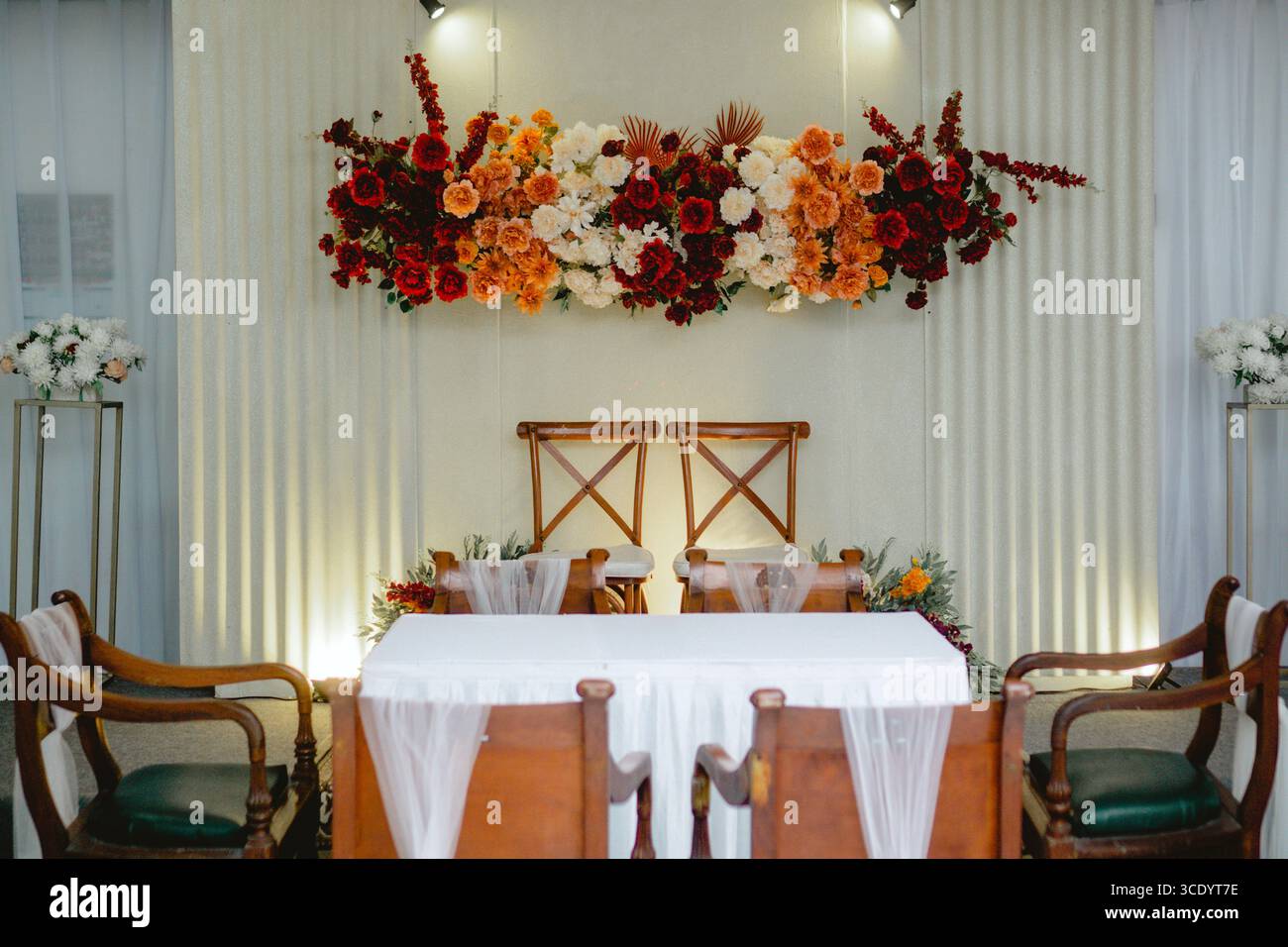 Elegant "akad" wedding decoration featuring red, orange, and white flowers as a central focus. Stock Photo