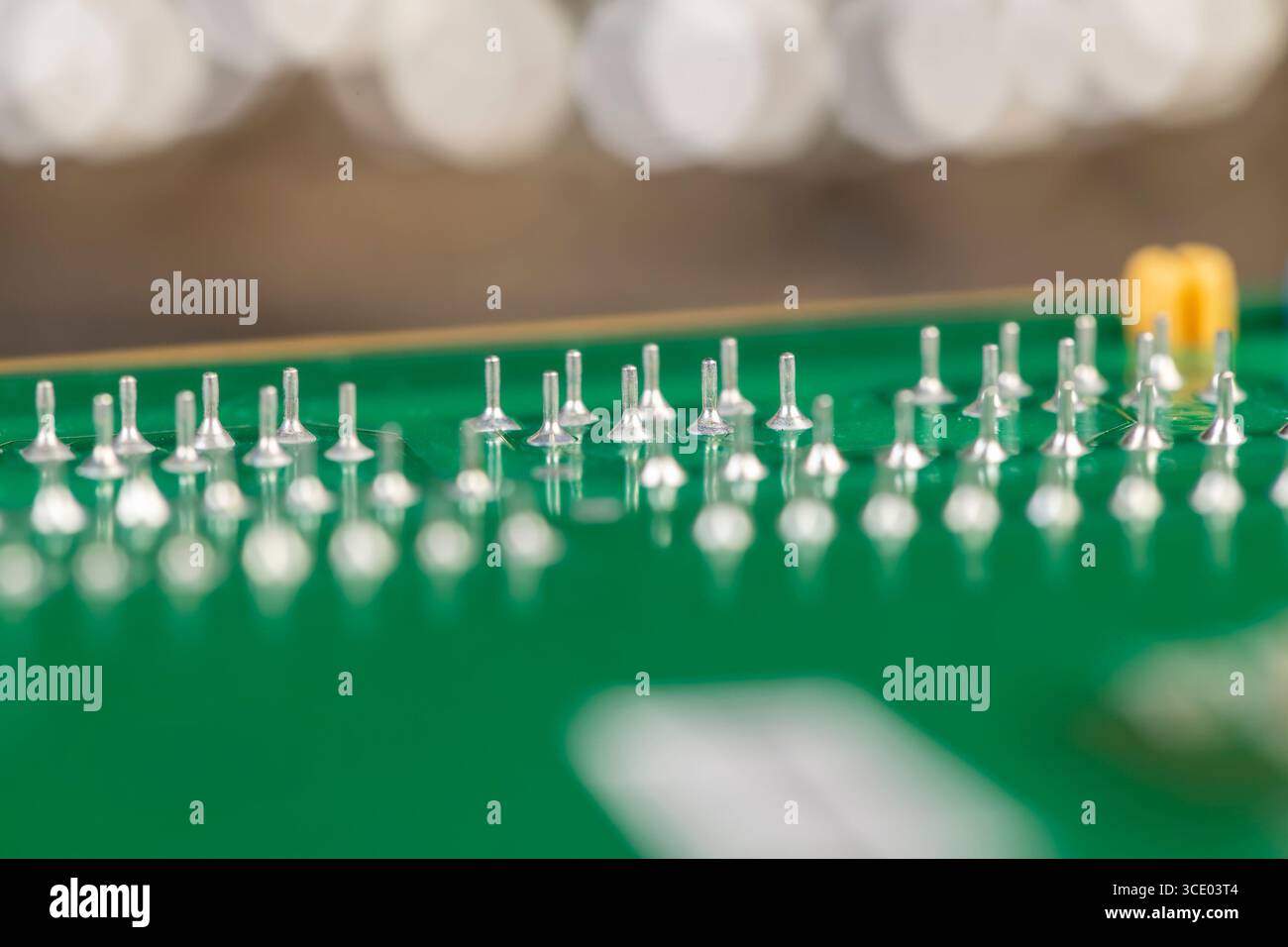 green circuit board with a large number of contacts, a simple green printed circuit board with an electronic circuit with soldered elements Stock Photo