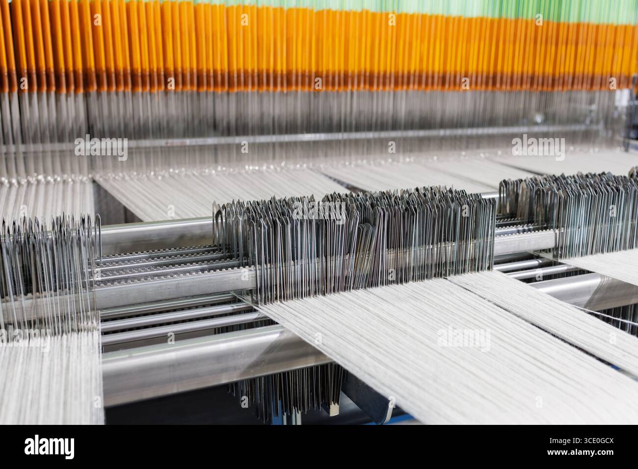 Detailed view of an industrial weaving loom showing warp, heddles and ...