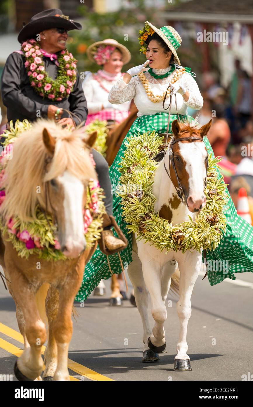 Pa’u rider wearing a green palaka print skirt adorned with flowers in ...