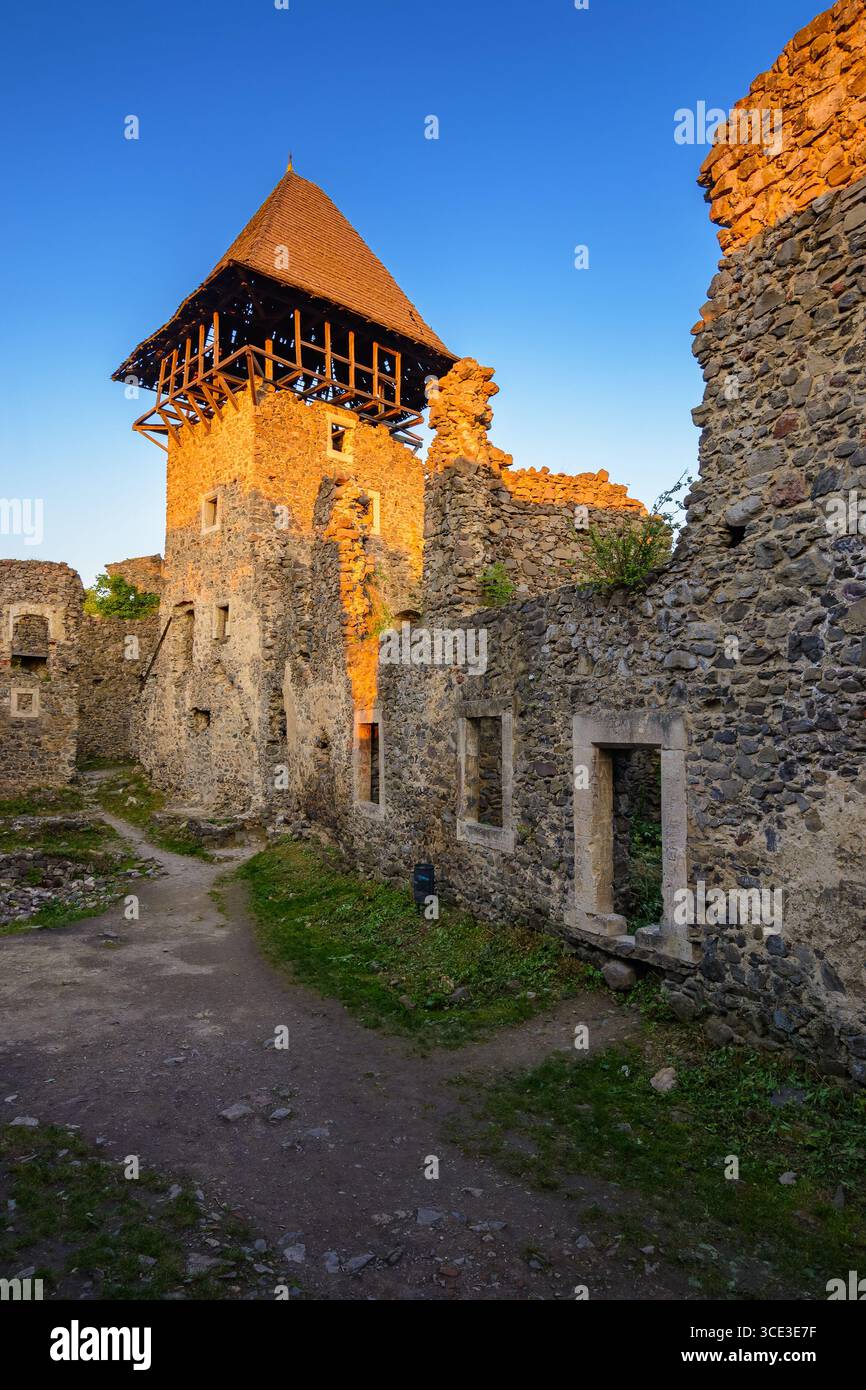 nevytske, ukraine - 19 may, 2018: castle with tower and stone wall at sunset. medieval fortress architecture of ukraine. travel destination and herita Stock Photo