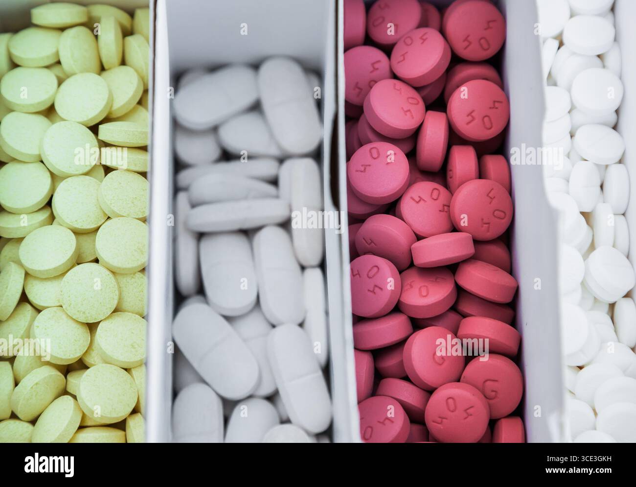 Four packages with multi-colored pills close-up. Stock Photo
